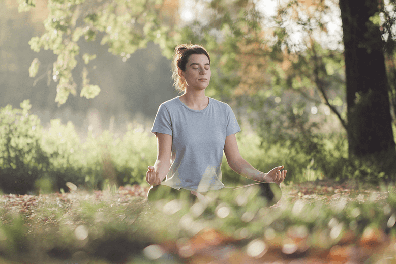 Mindfulness meditation for stress relief and well-being in a serene outdoor setting.