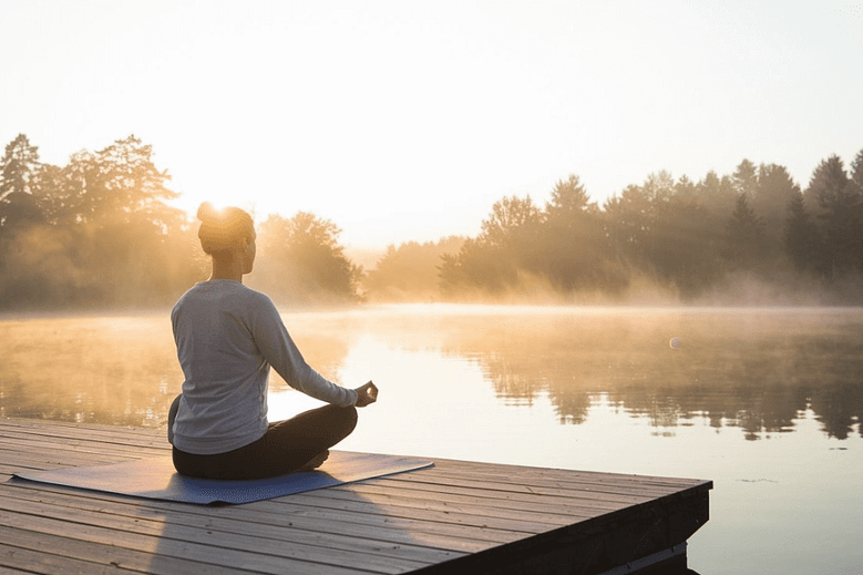 A serene meditation scene outdoors at sunrise for mindfulness and stress relief.